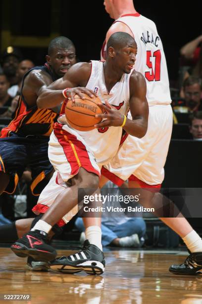 Dwyane Wade of the Miami Heat drives to the basket as his teammate Michael Doleac sets a pick on Jason Richardson of the Golden State Warriors during...