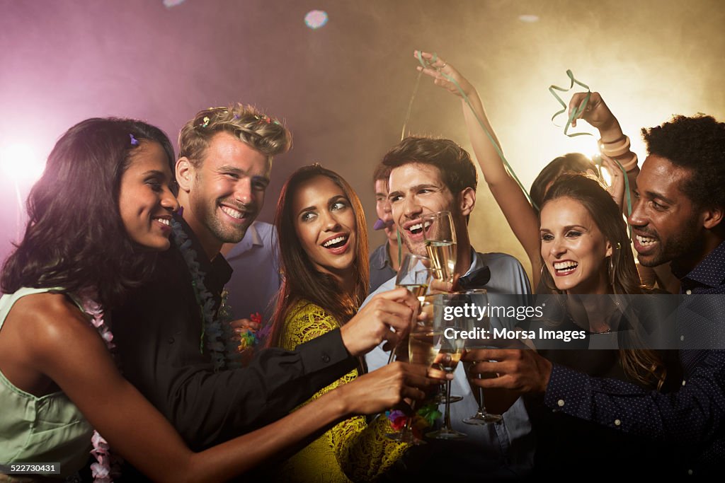 Friends toasting champagne flutes at nightclub