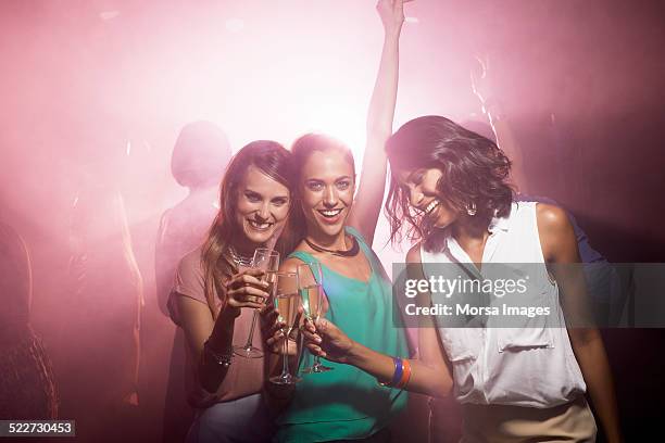 happy friends toasting champagne at nightclub - girls night stock pictures, royalty-free photos & images