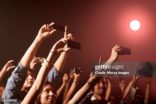 people photographing at nightclub - holding above head stock pictures, royalty-free photos & images