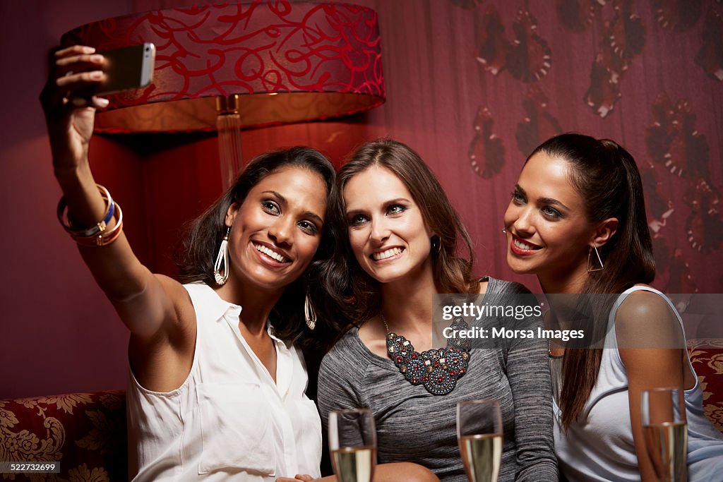 Happy friends taking self portrait at nightclub