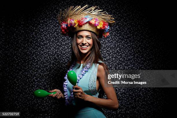 woman in straw hat shaking maracas at nightclub - maracas stockfoto's en -beelden