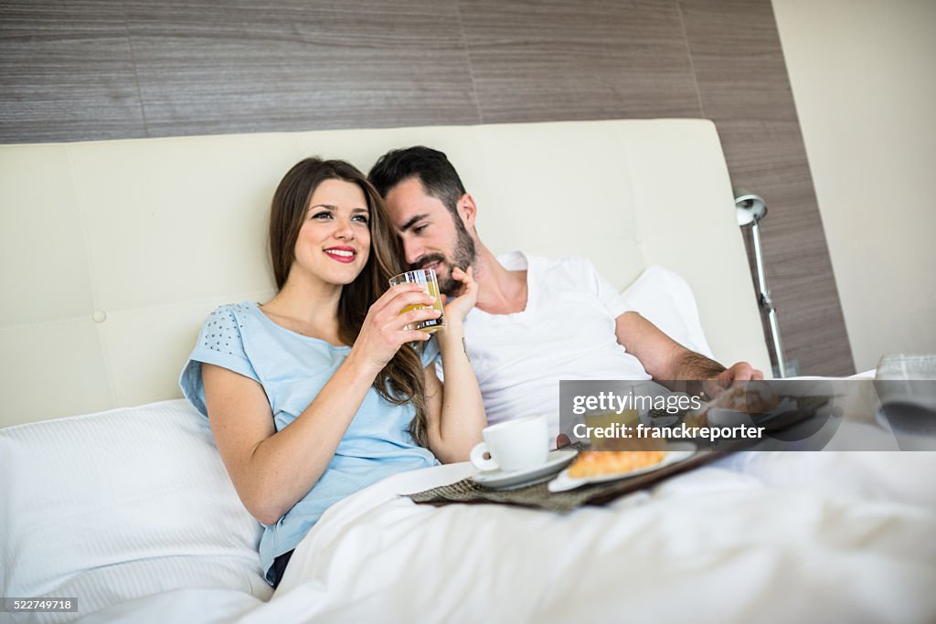 Couple doing breakfast on the bed