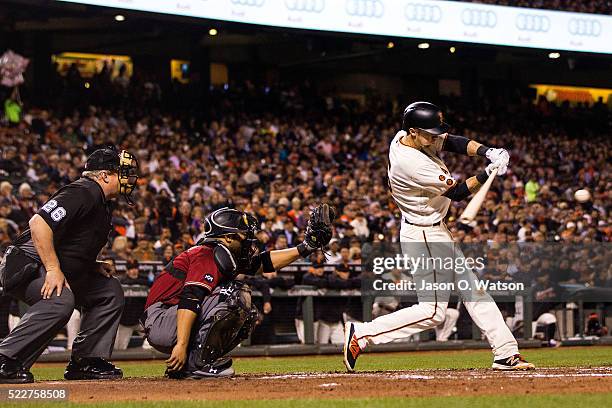 Matt Duffy of the San Francisco Giants hits a double in front of Welington Castillo of the Arizona Diamondbacks and umpire Bill Miller during the...