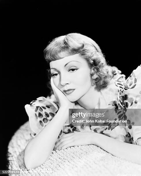 Portrait of actress Claudette Colbert posing with her head resting on her hand, for Paramount Pictures, 1938.