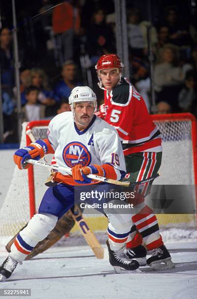 Canadian hockey player Bryan Trottier of the New York Islanders battles for position with Tom Kurvers of the New Jersey Devils during a game at...