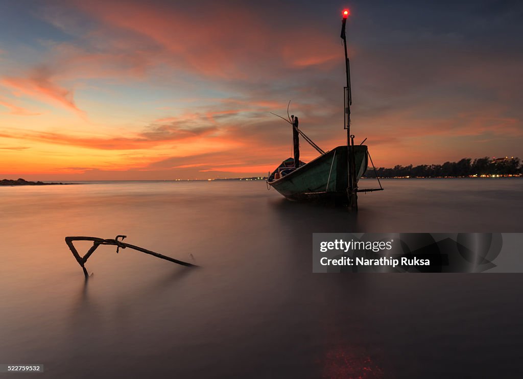 Fishing boat at the beach during sunset