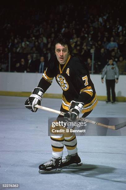 Canadian hockey player Phil Esposito of the Boston Bruins skates with the puck during a road game, 1970s.