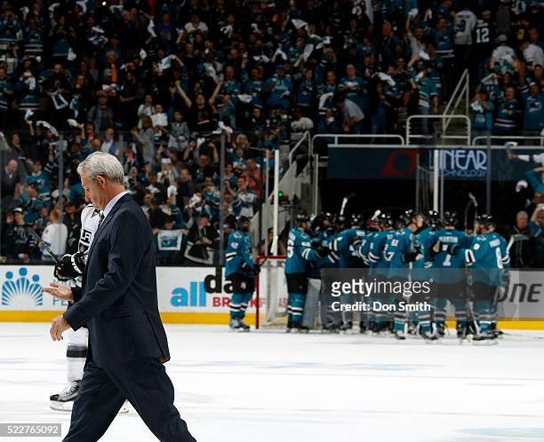 Head Coach Darryl Sutter of the Los Angeles Kings walks off as the San Jose Sharks celebrate on the ice after the San Jose Sharks victory during the...