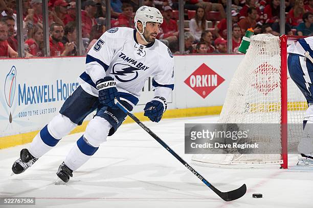 Jason Garrison of the Tampa Bay Lightning skates around the net with the puck during Game Three against the Detroit Red Wings of the Eastern...