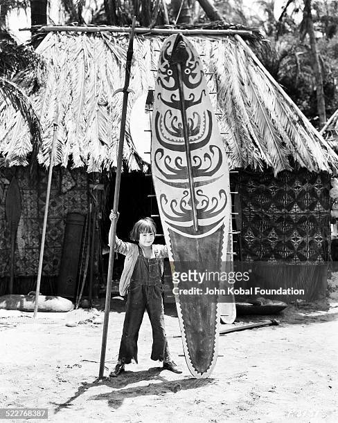 American actor Jackie Coogan holding a large shield on the set of the movie 'Little Robinson Crusoe', 1924.