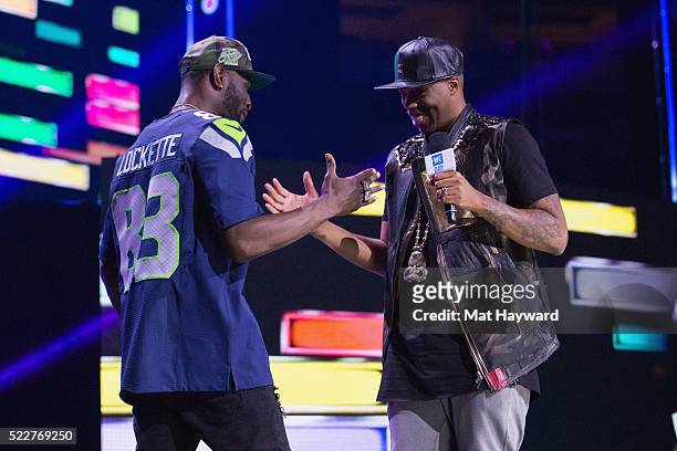 Seattle Seahawks Wide Receiver Ricardo Lockette and Kardinal Offishall shake hands on stage during We day at KeyArena on April 20, 2016 in Seattle,...