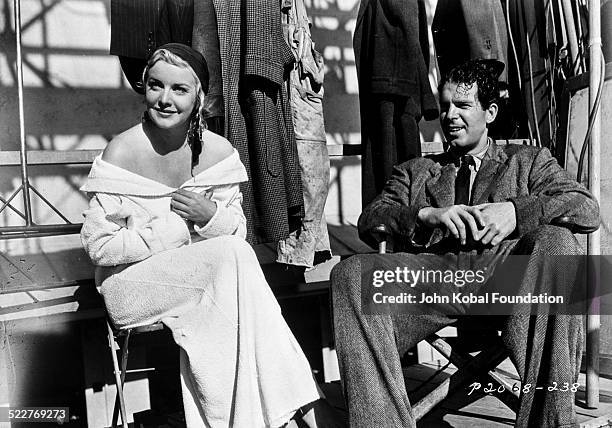 Actors Madeleine Carroll and Fred MacMurray resting between takes, on the set of a movie with Paramount Pictures, 1939.