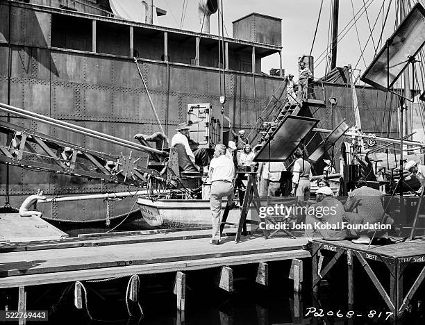 Actress Madeleine Carroll in a boat, surrounded by camera crew on a film set, with Paramount Pictures, 1939.