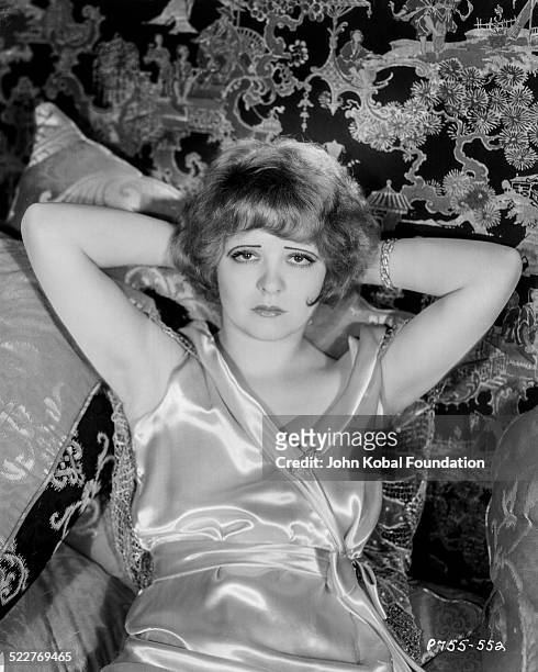 Portrait of actress Clara Bow reclining on a pile of pillows, for Paramount Pictures, 1929.