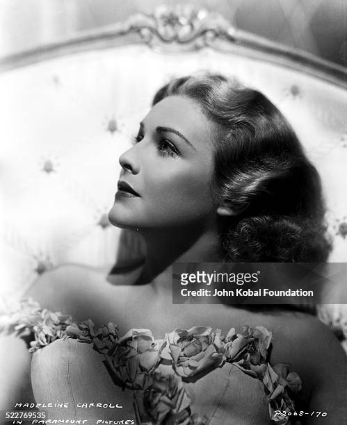 Headshot of actress Madeleine Carroll wearing a strapless, flower-trimmed dress, with Paramount Pictures, 1938.