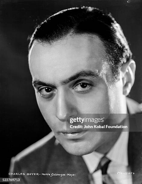 Headshot of actor Charles Boyer wearing a suit and tie, for MGM Studios, 1931.