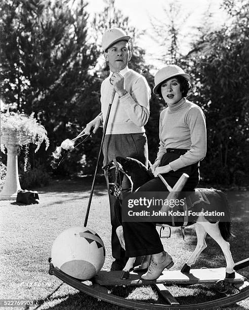 Comedy double act George Burns and Gracie Allen larking around with children's toys, with Paramount Pictures, 1936.