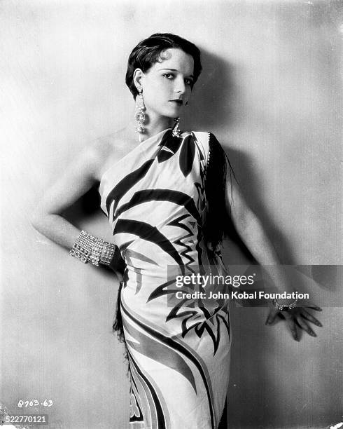 Portrait of actress Louise Brooks wearing statement jewelry and a patterned dress, for Paramount Pictures, 1923.