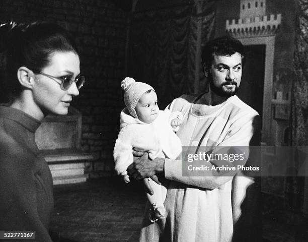 Actor Tony Curtis holding his baby daughter Allegra, with his wife Christine Kaufmann, on the set of the movie 'On My Way to the Crusades, I Met a...