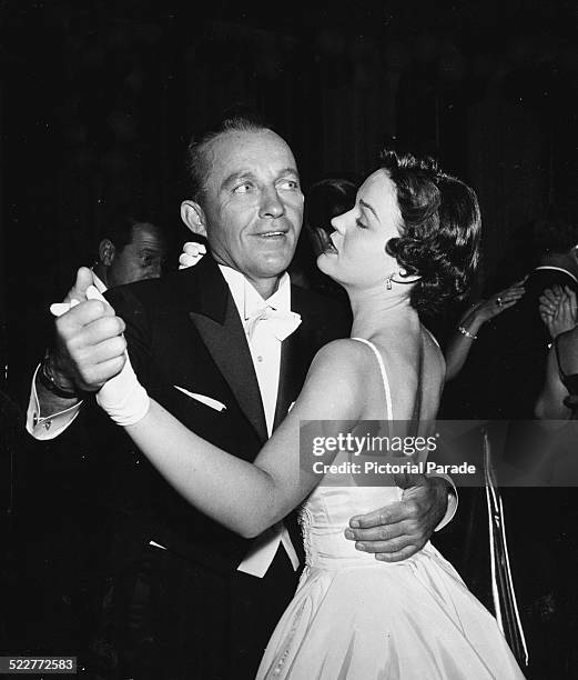 Actor and singer Bing Crosby, dancing with his wife Kathryn at a Hollywood event, circa 1957.