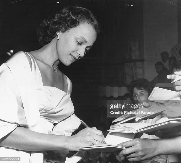 American actress, singer and dancer, Dorothy Dandridge signing autographs at the premiere of the film 'Porgy and Bess', Hollywood, August 1959.