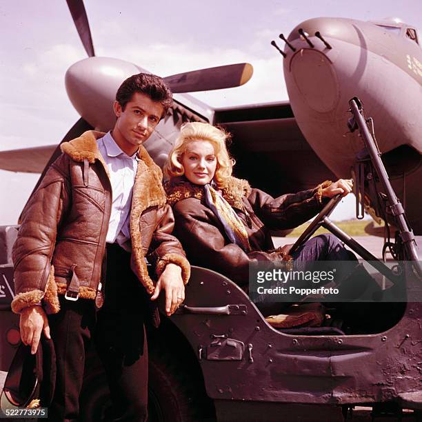 American actor George Chakiris and Austrian actress Maria Perschy posed together wearing sheepskin lined leather jackets in front of a de Havilland...