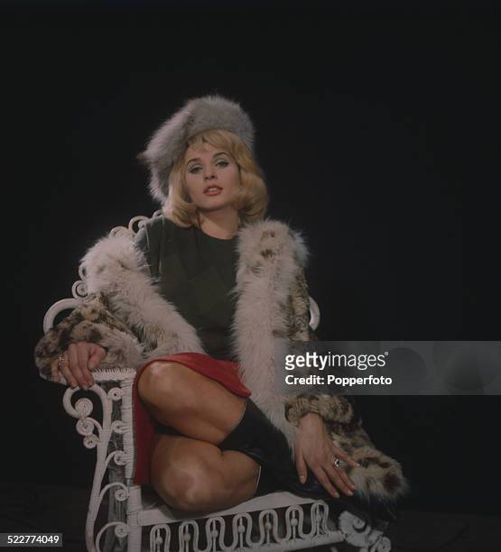 Austrian actress Senta Berger posed wearing a fur coat and hat on the set of the film 'The Victors' in 1963.
