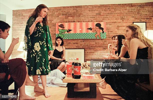 American actress, screenwriter, producer, and director Lena Dunham, standing, hosts a "Barefoot Formal" dinner party for twelve of her girlfriends...