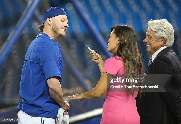 Josh Donaldson of the Toronto Blue Jays talks to Sportsnet reporter Hazel Mae and broadcaster Buck Martinez during batting practice before the start...