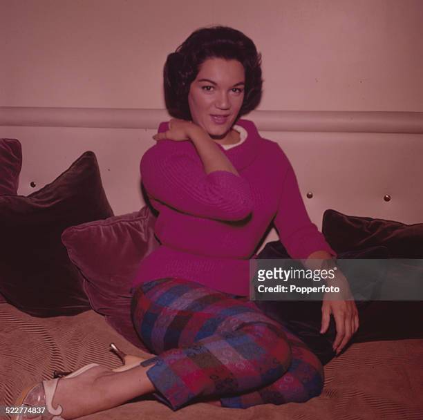 American singer Connie Francis posed wearing a pink roll necked jumper and checked capri trousers in London in 1963.