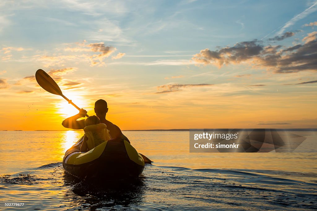 Having Fun Sea Kayaking At Sunset