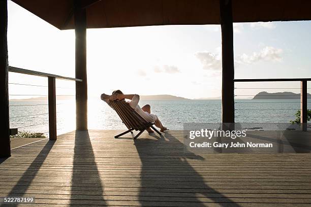 woman relaxing in deck chair on veranda. - relax holiday bildbanksfoton och bilder