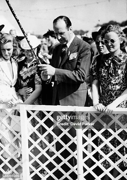 Actor Cecil Parker fishing for bottles of champagne, at the Theatrical Garden Party, Ranelagh, England, June 7th 1939.