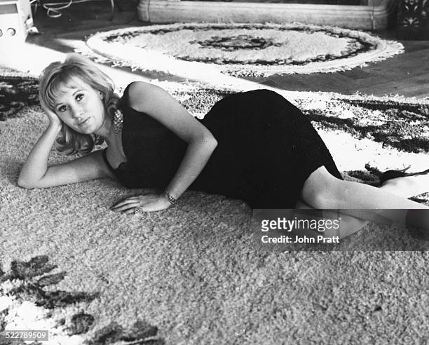 Portrait of singer Janie Jones lying on a rug on the floor, prior to her arrest on vice charges, circa 1975.