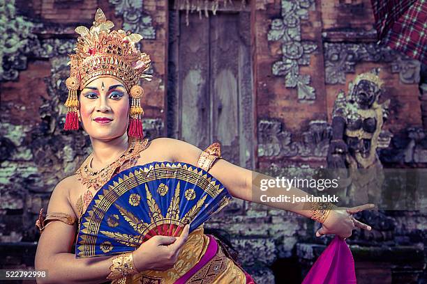 vintage bali performing dancer in a temple with fan - bali dancing stock pictures, royalty-free photos & images