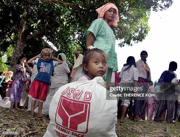 Young Muslim girl sit beside a bag of relief good at a distribution center in Panamao town, southern Jolo island 05 March 2005. The department of...