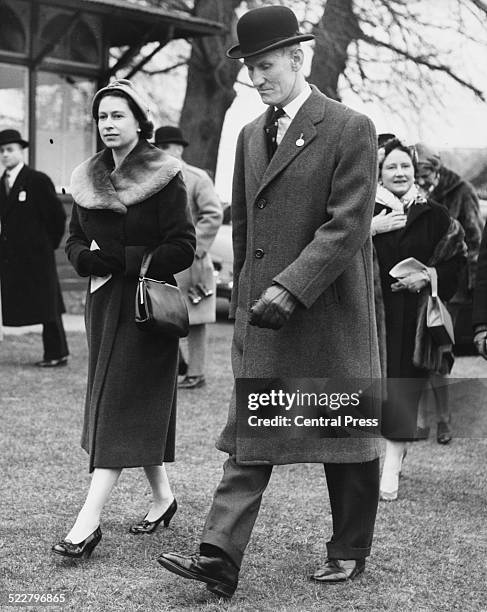 Queen Elizabeth II and General Sir Richard McCreery, with the Queen Mother behind, walking in the paddock at Sandown Park, for a Grand Military...