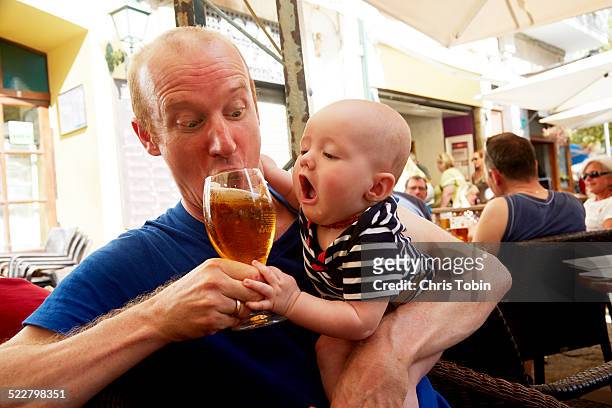 baby trying to drink beer - biergarten stock-fotos und bilder