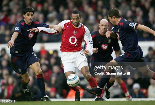 Thierry Henry of Arsenal breaks through Dejan Stefanovic and Arjan De Zeeuw of Portsmouth during the Barclays Premiership match between Arsenal and...