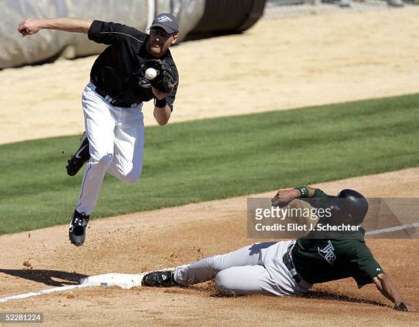 Infielder Corey Koskie of the Toronto Blue Jays is unable to tag out Chris Singleton of the Tampa Bay Devil Rays at third base on March 5, 2005 at...