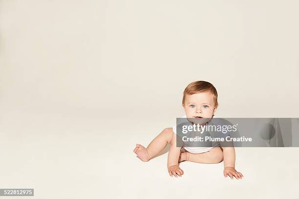 cute baby crawling on the floor - baby studio stock pictures, royalty-free photos & images