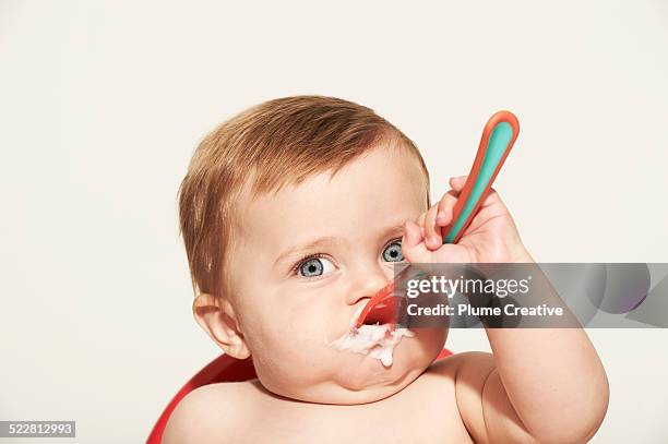 baby shoving food in his face - funny baby photo - fotografias e filmes do acervo