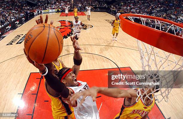 Allen Iverson of the Philadelphia 76ers drives for a layup against Obinna Ekezie and Josh Childress of the Atlanta Hawks on March 5, 2005 at Philips...