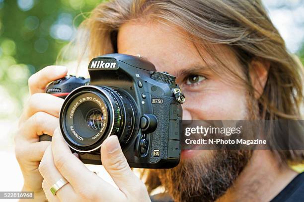 Portrait of a photographer taking pictures with a Nikon D750 DSLR on a summery day, taken on August 6, 2015.