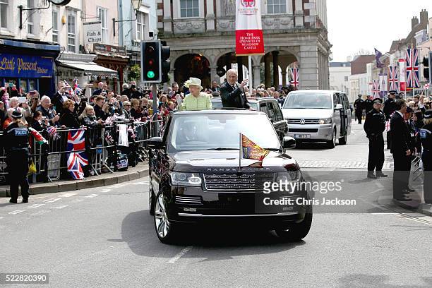 Queen Elizabeth II and Prince Philip, Duke of Edinburgh wave from the top of an open Range Rover on the monarch's 90th Birthday on April 21, 2016 in...