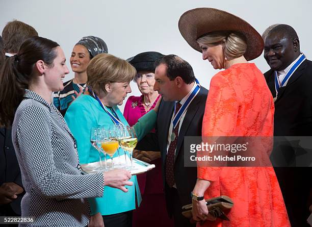 German Chancellor Angela Merkel talks with Mazen Darwish while Queen Maxima of The Netherlands is offered a drink after the Four Freedoms Awards...