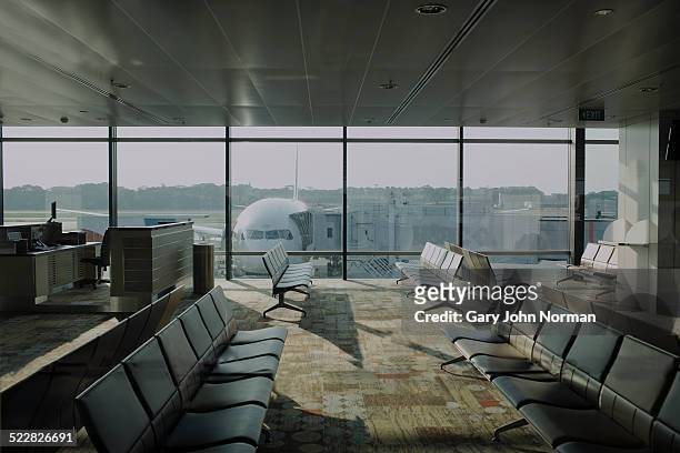 empty airport lounge with plane outside. - vertrekhal stockfoto's en -beelden