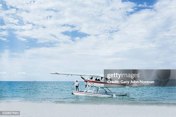 seaplane landed on tropical beach. - watervliegtuig stockfoto's en -beelden