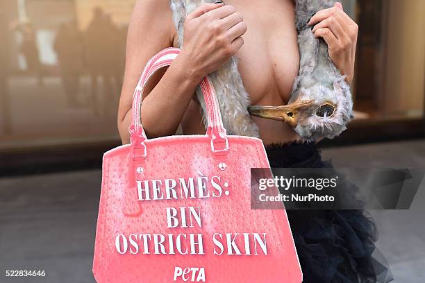 Model Katie Doherty from Co.Kerry, covered by an ostrich &quot;corpse&quot; and carrying an handbag-shaped sign, during PETA protest against the use...